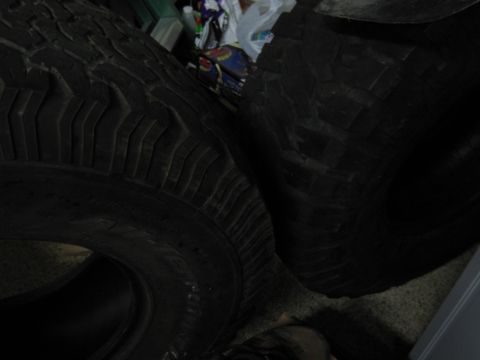 1986 Ford Bronco - Close-up view of two tires, one with a prominent tread pattern, suggesting off-road or heavy-duty use.