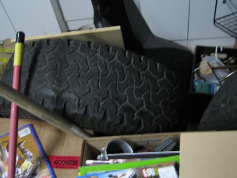 1986 Ford Bronco - Storage area with a tire and various miscellaneous items, including some magazines.