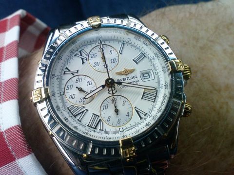 1998 Ford Crown Victoria - A man's wrist is adorned with a detailed Breitling Chronometre watch, multiple subdials.