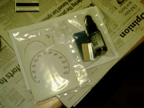 1976 Ford Ranchero - Gauge faces and a stain kit are shown packaged on top of newspapers.