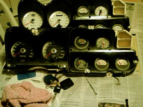 1976 Ford Ranchero - A collection of automotive dashboard gauges and indicators are laid out on a newspaper.