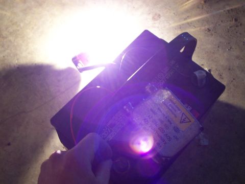 1993 Ford Probe - A car headlight ballast is shown with readable text and a bright light.