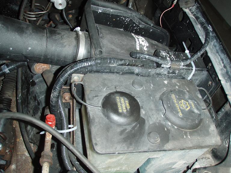 Black plastic master cylinder and reservoir in an engine bay