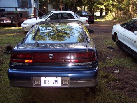 1995 Mitsubishi Eclipse - Eagle Talon TSi seen from the rear, parked outdoors with other vehicles.