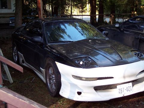 1995 Mitsubishi Eclipse - Front view of a modified sports car with custom bodywork and aftermarket wheels.