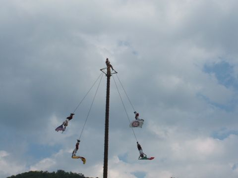 1966 Ford Ranchero - A group of performers are suspended from a tall pole, some holding flags, during an outdoor event.
