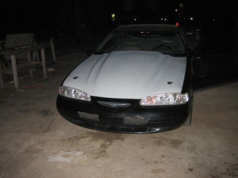 1996 Ford Thunderbird - A 1996 Ford Thunderbird is parked outside with its hood up and driver's door open.