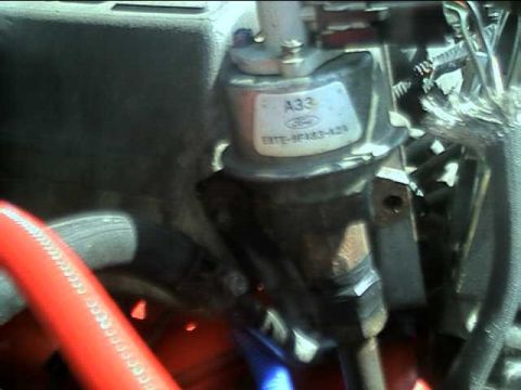 1989 Ford Bronco - A close-up view of a vehicle's engine component, showing a label with part information.