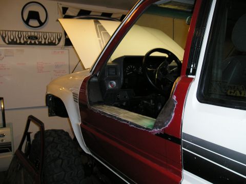 1986 Toyota Hilux - This truck is undergoing modifications, with the driver's side door removed and bodywork in progress.