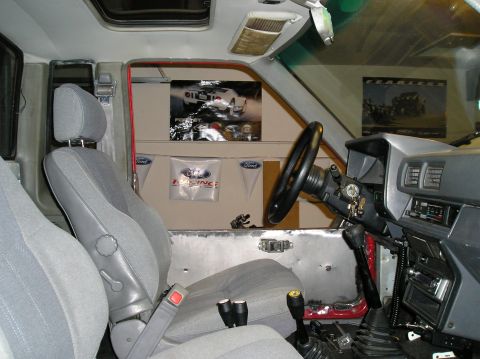 1986 Toyota Hilux - The interior of a truck shows grey seats and a dashboard with various controls and a radio.