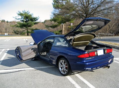 1993 Ford Probe - A blue 1993 Ford Probe GT is shown with its hood, driver's door, and trunk open in a parking lot.