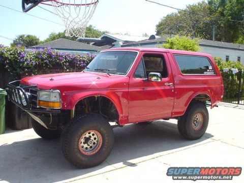 1993 Ford Bronco - This red 1993 Ford Bronco features an aftermarket bumper and lifted suspension, giving it a appearance.