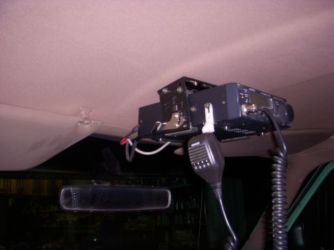 1996 Ford Bronco - Aftermarket radio and microphone installed on the interior ceiling of a vehicle.