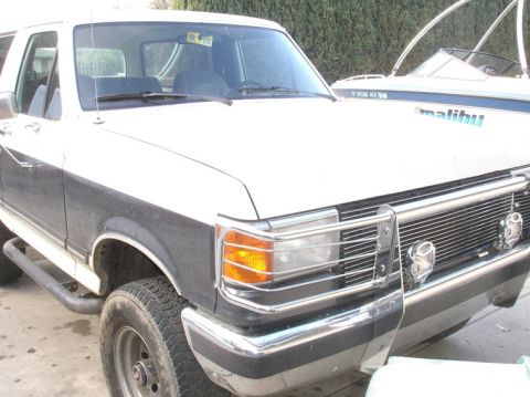 1989 Ford Bronco - Front view of a white and gray 1989 Ford Bronco with aftermarket grille guard.