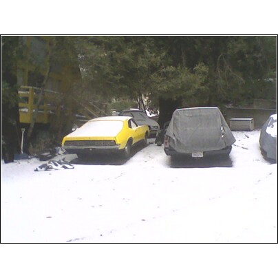 1972 Ford Ranchero - A yellow 1972 Ford Ranchero is parked in the snow next to other vehicles.