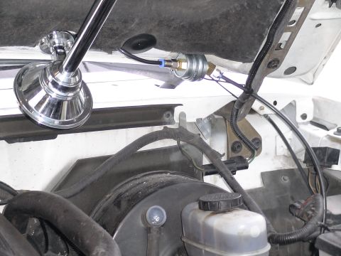 1993 Ford C-350 (Centurion Conversions) - Close-up of an aftermarket air horn and its associated pressure switch installed under the hood.