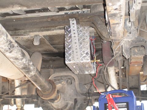 1993 Ford C-350 (Centurion Conversions) - Aftermarket air tank mounted beneath a vehicle, connected to wiring and a brass valve.