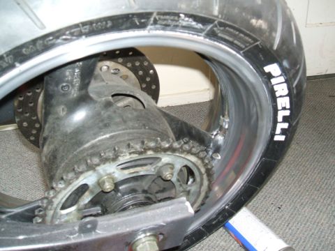 2004 Yamaha FZR600 - Close-up view of a motorcycle's rear wheel assembly, showing the tire, chain, and brake rotor.
