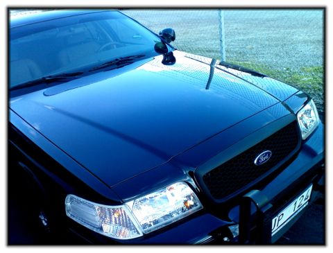 1998 Ford Crown Victoria - This Ford Crown Victoria features a black grille and a push bar, with a visible license plate.