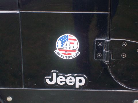 2005 Jeep Wrangler - Close-up of a Jeep door, showing a branded sticker and the vehicle's manufacturer badge.