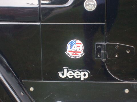 2005 Jeep Wrangler - Close-up of a black Jeep Wrangler door, showing the 'Jeep' emblem and a circular decal.