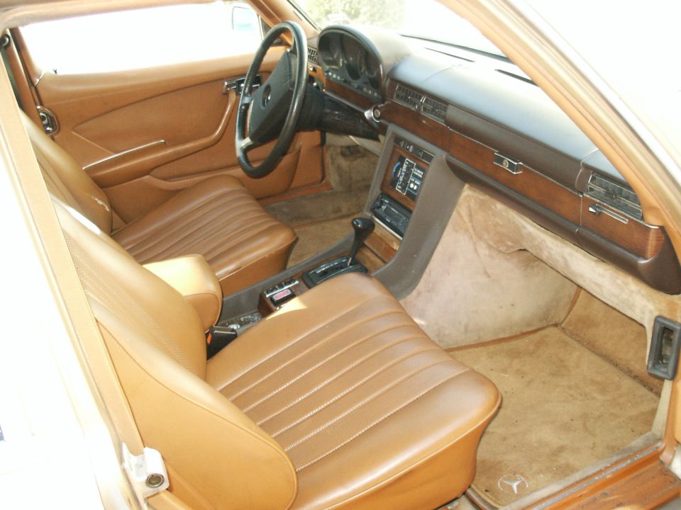Tan interior of a 1980 Mercedes-Benz S-Class, showing seats, dashboard, and steering wheel