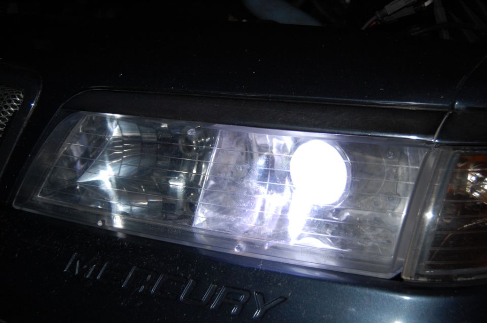 Illuminated Mercury headlight with bright white bulb and MERCURY lettering below