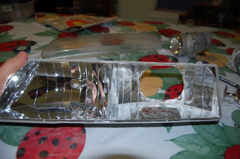 1985 Mercury Grand Marquis - A disassembled car headlight assembly is shown on a table with a ladybug-themed tablecloth.