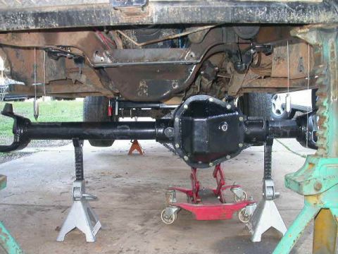 1990 Ford Bronco - A coupe of plumb bobs hung through the center bolt hole of the coil bucket help get the axle centered up under the truck.