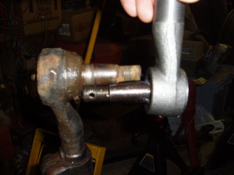 1980 Ford Bronco - Close-up of steering linkage parts, one showing rust and wear, the other appearing new.