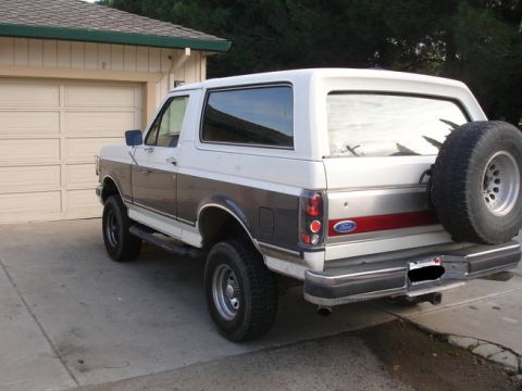 1989 Ford Bronco - Rear view of a two-tone 1989 Ford Bronco with a spare tire mounted on the back.
