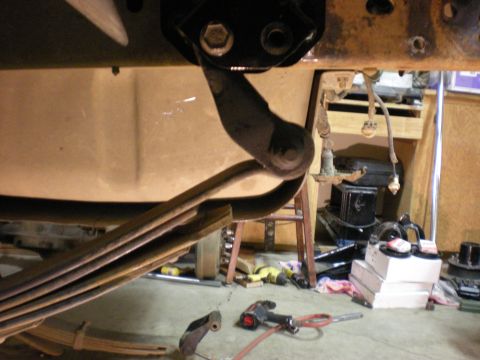 1993 Ford Bronco - Underside view of vehicle suspension parts and tools on the garage floor.