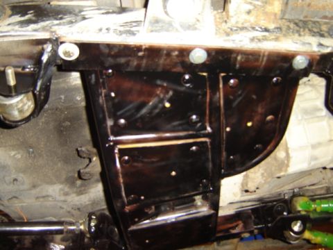 1992 Ford Bronco - Close-up view of a black-coated underbody chassis component, numerous bolts and a Supermotors.net watermark.