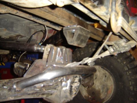 1992 Ford Bronco - Custom suspension parts are visible on the underside of a vehicle, with visible welding and metal fabrication.