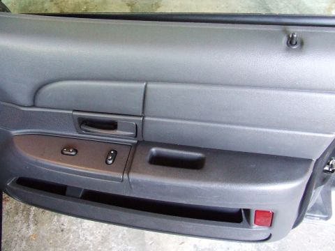 2003 Ford Crown Victoria - Close-up of a car's interior door panel, showing the power window controls and a red reflector.