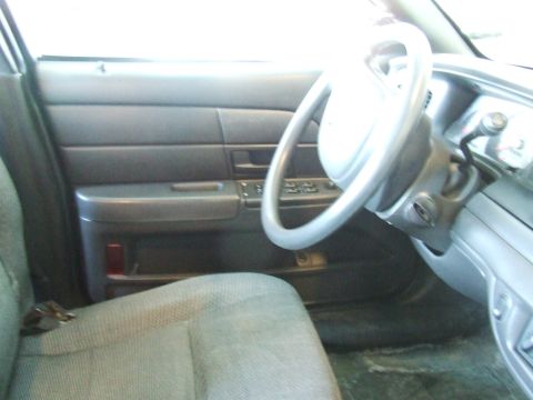 2003 Ford Crown Victoria - Interior view of a 2003 Ford Crown Victoria, highlighting the driver's side door panel, seat, and steering wheel.