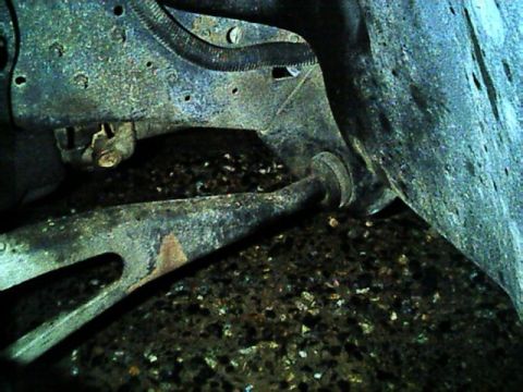 1989 Ford Bronco - This image shows the underside of a vehicle, focusing on suspension components and a portion of the tire.