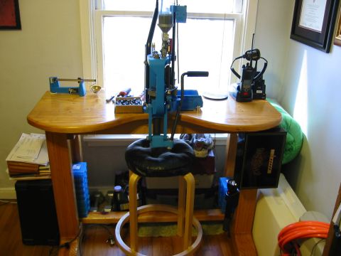 1996 Ford Bronco - A workbench setup features a reloading press, a scale, and communication devices near a window.