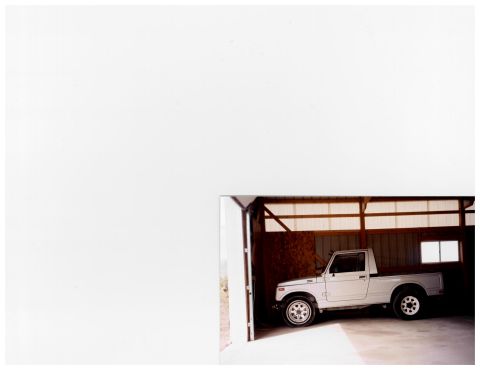 1988 Suzuki Samurai - A white 1988 Suzuki Samurai pickup truck is parked inside a garage, with the front-left side visible.