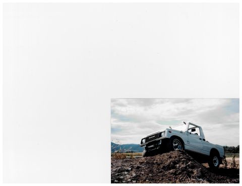 1988 Suzuki Samurai - A white 1988 Suzuki Samurai pickup truck is shown on a dirt mound under a cloudy sky.