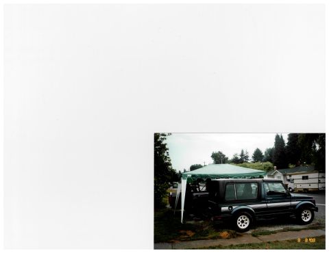 1988 Suzuki Samurai - A Suzuki Samurai is parked under a canopy with a residential area in the background.
