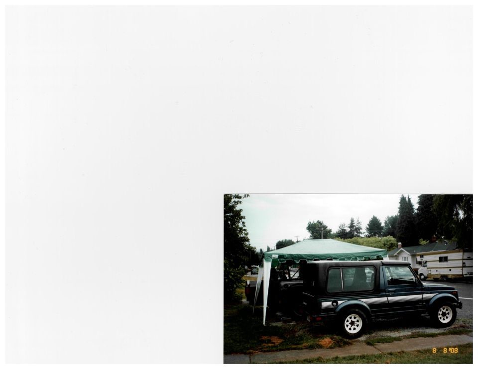 Dark green Suzuki Samurai hardtop with silver stripes parked under a green canopy