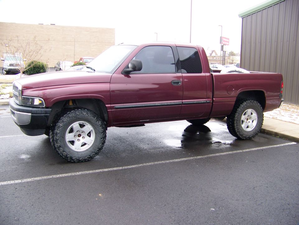 maroon pickup truck parked on wet asphalt
