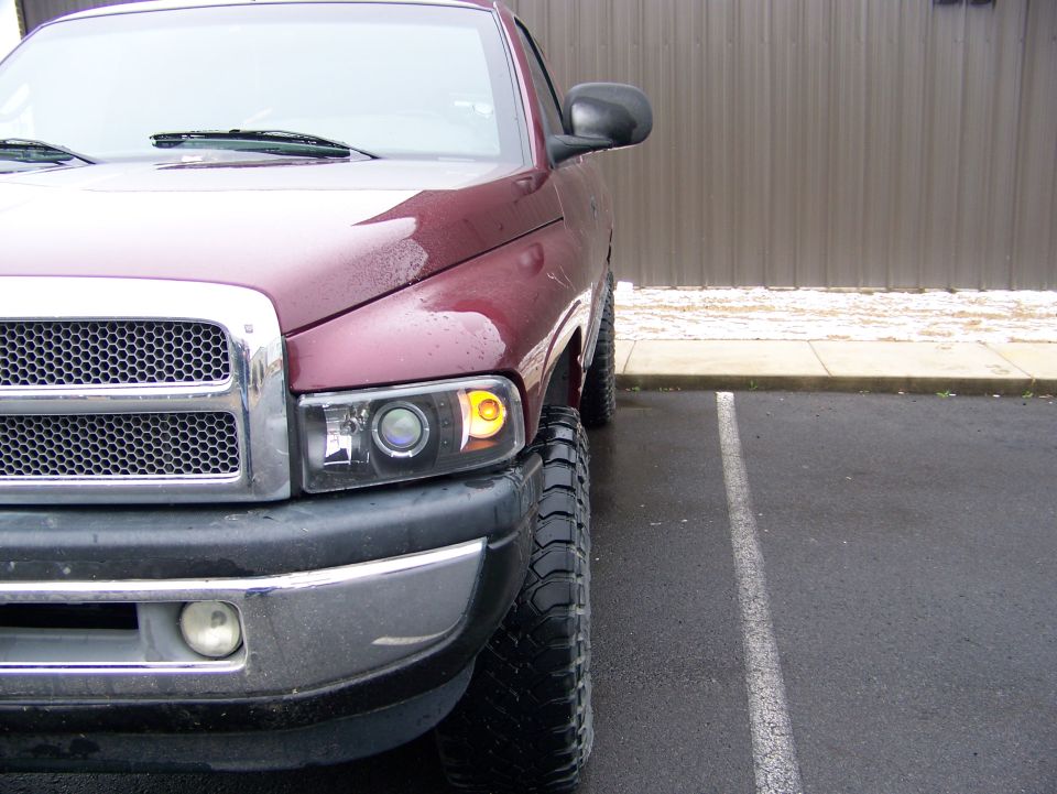 Maroon 2001 Dodge 1500 pickup truck front corner with chrome grille and aftermarket headlights