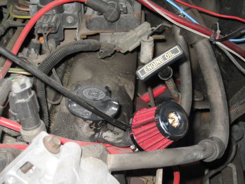 1994 Ford Bronco - Close-up of an engine bay with a red aftermarket air filter and an engine oil dipstick visible.
