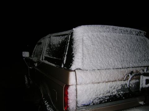 1996 Ford Bronco - A tan Ford Bronco sits covered in snow during a winter night.