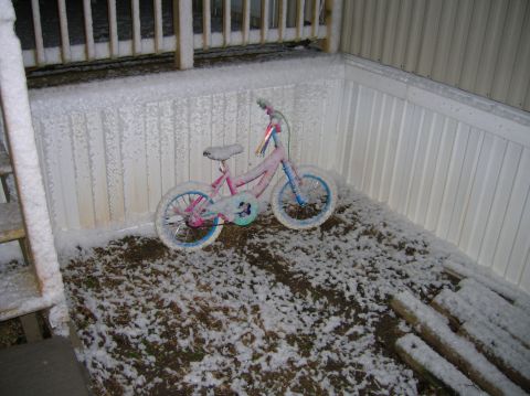 1996 Ford Bronco - A child's bicycle sits on a snow-covered deck next to a white railing.