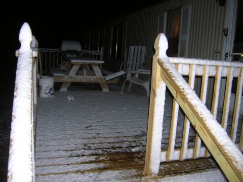 1996 Ford Bronco - A snow-covered porch features a picnic table and chairs, with a mobile home in the background.