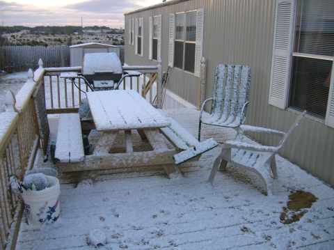 1996 Ford Bronco - A snow-covered deck with outdoor furniture and a grill sits outside a mobile home.