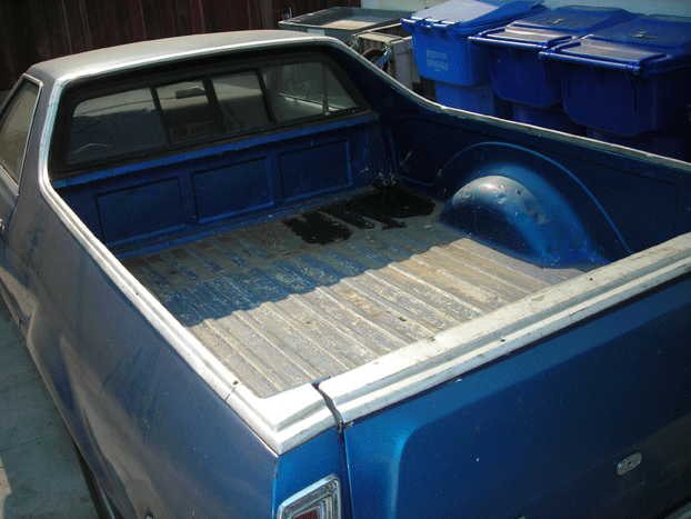 Empty wooden cargo bed of a blue car-based pickup